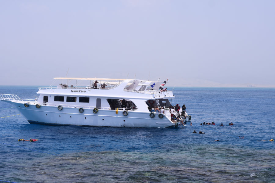 A boat anchored by a coral reef in Sharm